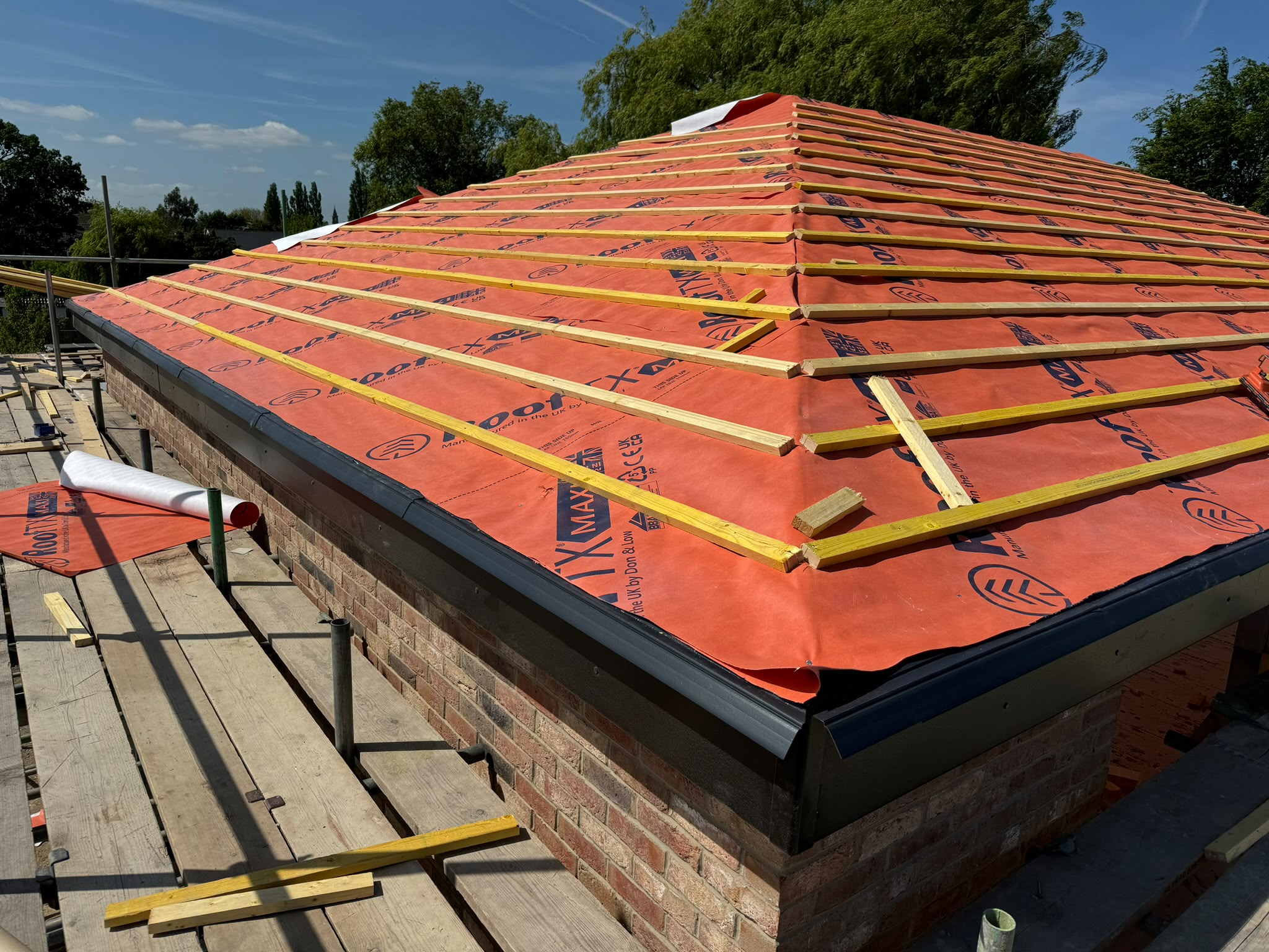 A pitched roof being re-tiled during a full re-roof