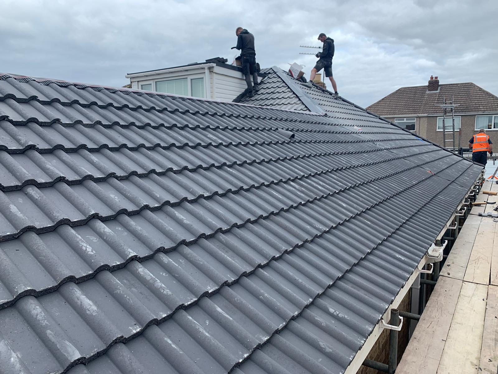 New interlocking roof tiles being fitted on a membrane